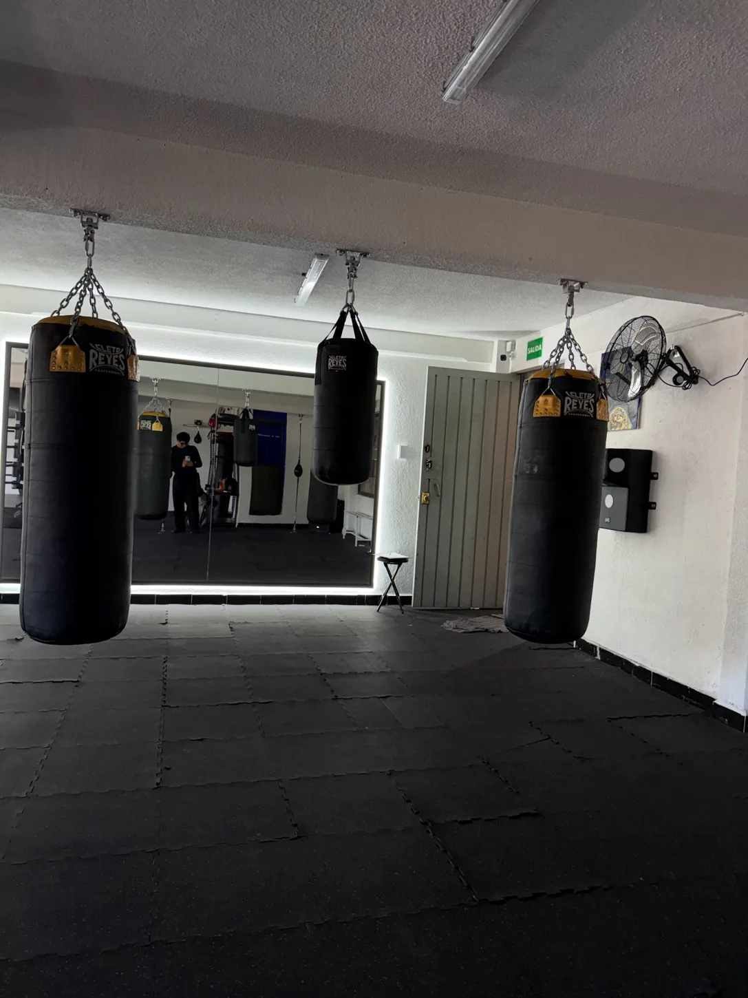 Costales de boxeo y superficie de entrenamiento frente al espejo